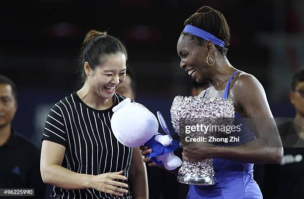 Former WTA player Li Na presents a gift to Venus Williams of USA along with the trophy after winning the final match against Karolina Pliskova of...