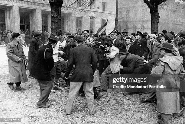 Member of the Hungarian secret police is surrounded by the enraged crowd after his capture during the revolt of the Hungarian people against the...