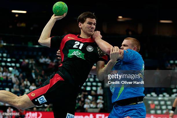 Erik Schmidt of Germany challenges for the ball with Matej Gaber of Slovenia during the Handball Supercup between Germany and Slovenia on November 8,...