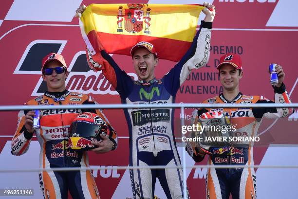 Movistar Yamaha's Spanish rider Jorge Lorenzo celebrates on podium winning the race and the 2015 MotoGP world championship tiltle with Repsol Honda's...