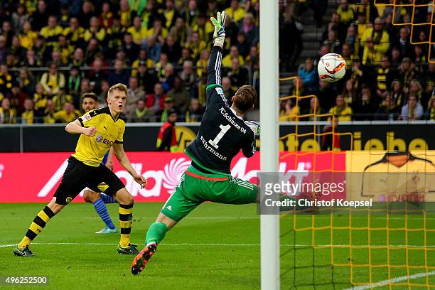 Matthias Ginter of Dortmund scores the second goal against Ralf Faehrmann of Schalke during the Bundesliga match between Borussia Dortmund and FC...