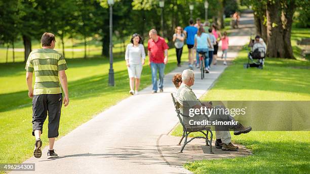 people walking in park - public park people stock pictures, royalty-free photos & images