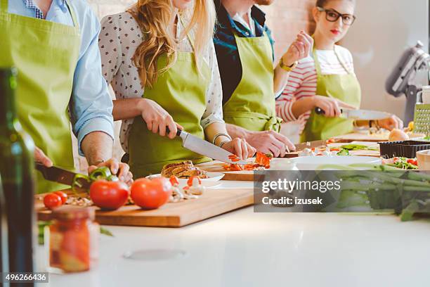 quatre personnes prenant part à un cours de cuisine - cours de cuisine photos et images de collection