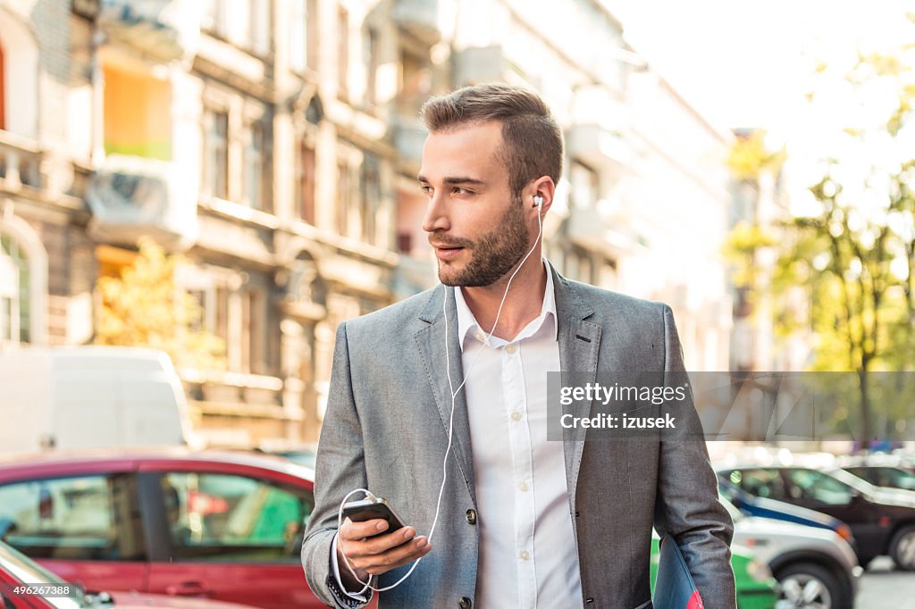 Young businessman talking on smart phone in the city