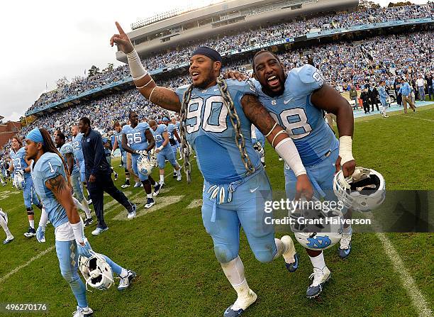 Nazair Jones and Justin Thomason of the North Carolina Tar Heels celebrate after a win against the Duke Blue Devils at Kenan Stadium on November 7,...