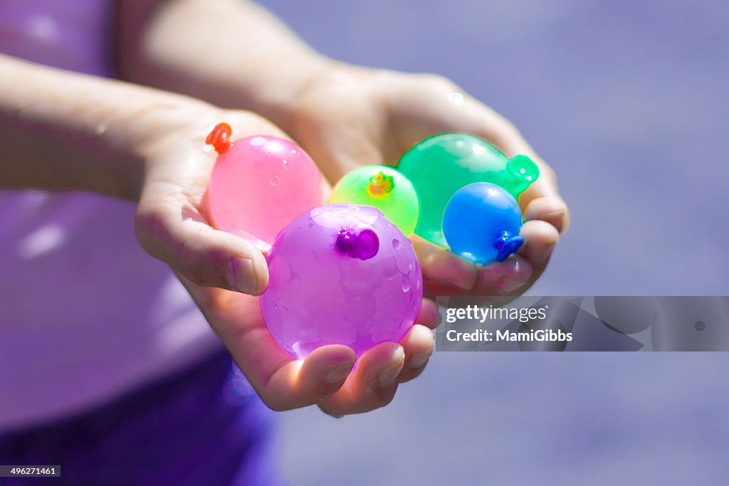 Colorful water balloons in hands