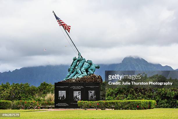 Yellow Airplane Flying a Large American Flag Over The Ko'olau Mountain Range with the Iwo Jima Memorial in the Foreground Aboard Marine Corps Base...