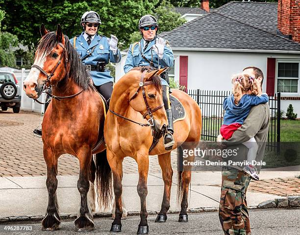 Mounted police greet young girl and her father before start of Memorial Day parade.