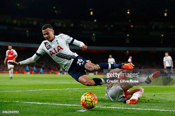Dele Alli of Spurs is tackled by Mathieu Debuchy of Arsenal during the Barclays Premier League match between Arsenal and Tottenham Hotspur at the...