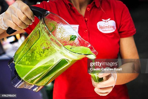 The staff at a stand of sKeimling Naturkost GmbH pours a sample of a green smoothie into a plastic cup at the Veggie World 2015 Vegan Trade Fair on...