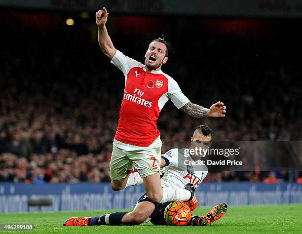 Mathieu Debuchy of Arsenal is fouled by Erik Lamela of Tottenham during the Barclays Premier League match between Arsenal and Tottenham Hotspur at...