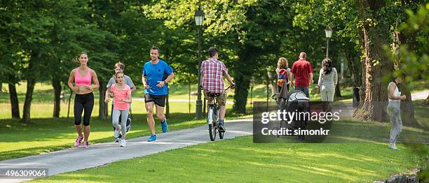 menschen beim joggen im park - two kids with cycle stock-fotos und bilder