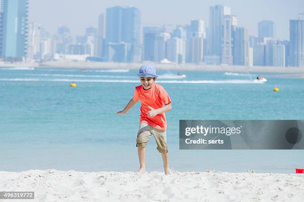 little boy feeling a freedom on sandy beach - dubai boy stock pictures, royalty-free photos & images