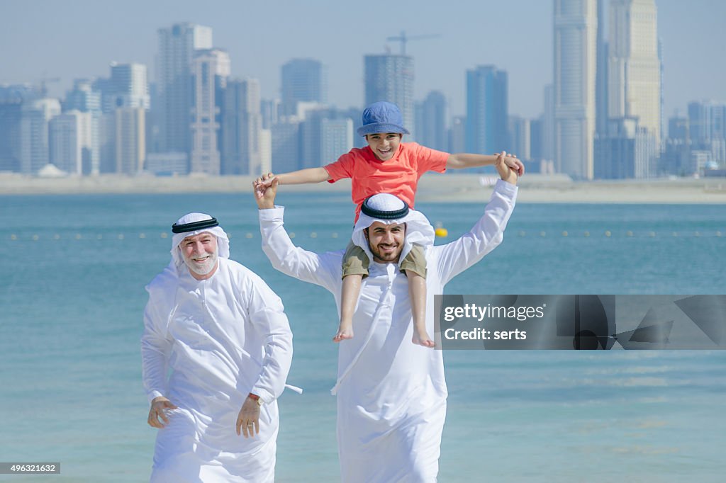 Arab father and son having fun at beach