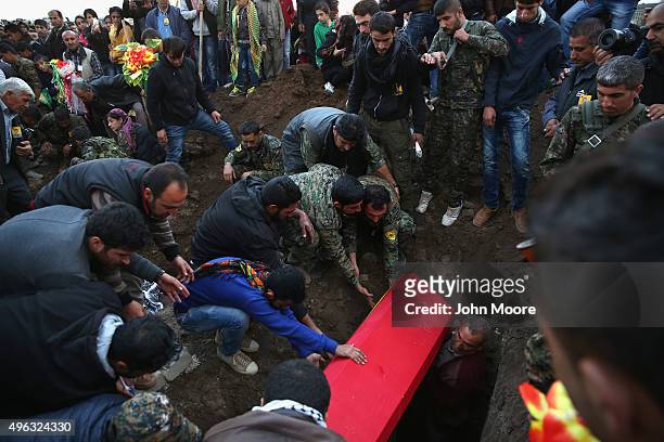 Comrades and family members bury the body of a People's Protection Units , soldier, one of eight comrades laid to rest November 8, 2015 in Derek,...