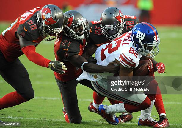 Wide receiver Rueben Randle of the New York Giants is tackled by a trio of Tampa Bay Buccaneers in the second quarter at Raymond James Stadium on...