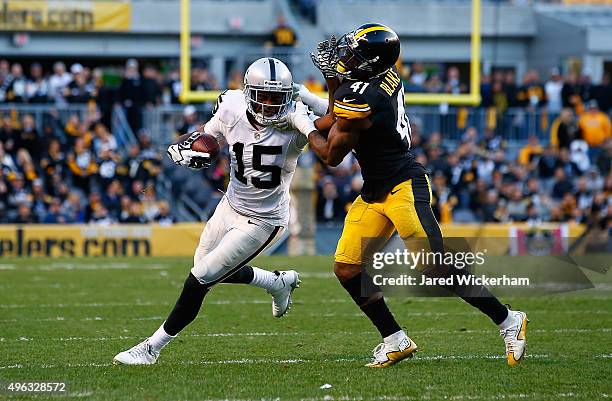 Michael Crabtree of the Oakland Raiders stiff arms Antwon Blake of the Pittsburgh Steelers after catching a pass in the 4th quarter of the game at...