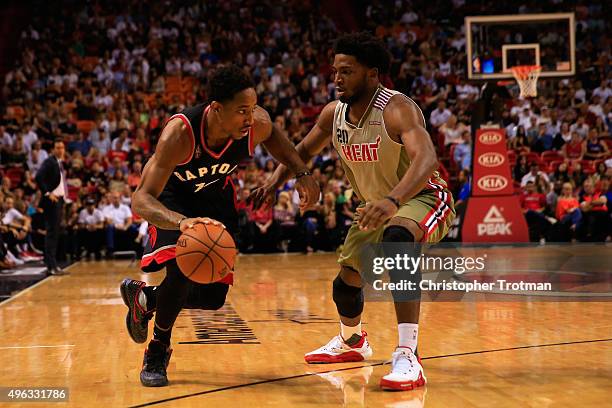 DeMar DeRozan of the Toronto Raptors dribbles the ball under pressure from Justise Winslow of the Miami Heat at American Airlines Arena on November...