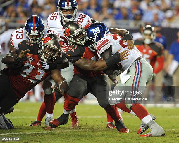 Running back Rashad Jennings of the New York Giants is tackled by defensive end William Gholston of the Tampa Bay Buccaneers in the fourth quarter at...