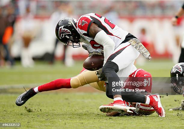 Jerome Simpson of the San Francisco 49ers catches the ball and then is hit by Ricardo Allen of the Atlanta Falcons and then Phillip Adams of the...