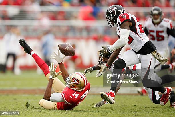 Jerome Simpson of the San Francisco 49ers catches the ball and then is hit by Ricardo Allen of the Atlanta Falcons and then Phillip Adams of the...