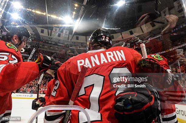 Artemi Panarin of the Chicago Blackhawks celebrates with teammates next to the glass after scoring his second goal in the first period of the NHL...