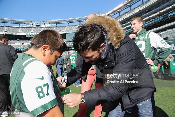 New York City FC Soccer Star David Villa signs an autographfor a young fan when he attends the New York Jets vs Jacksonville Jaguars game at MetLife...