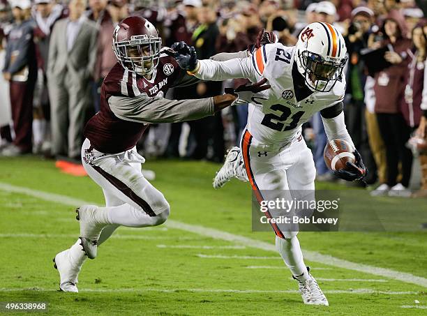 Kerryon Johnson of the Auburn Tigers steps out of bounds before crossing ther goal line as Nick Harvey of the Texas A&M Aggies pushes him out in the...