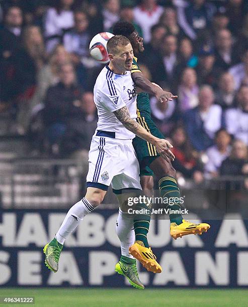 Jordan Harvey of the Vancouver Whitecaps FC and Dairon Asprilla of the Portland Timbers head the ball during the second leg of their Western...