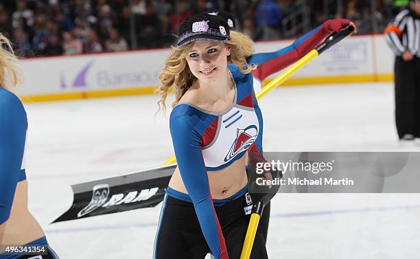 Member of the of the Colorado Avalanche ice girls cleans the ice during a break in the action at the Pepsi Center on November 3, 2015 in Denver,...