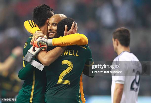 Octavio Rivero of the Vancouver Whitecaps FC looks on dejected as Adam Kwarasey of the Portland Timbers is congratulated by teammates Norberto...