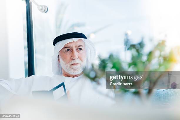 senior arabian man with cellphone - arab businessman stock pictures, royalty-free photos & images