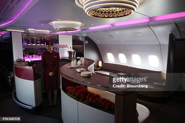 Member of the flight crew stands at the bar for business class passengers aboard an Airbus A380-800 aircraft, operated by Qatar Airways Ltd., on the...