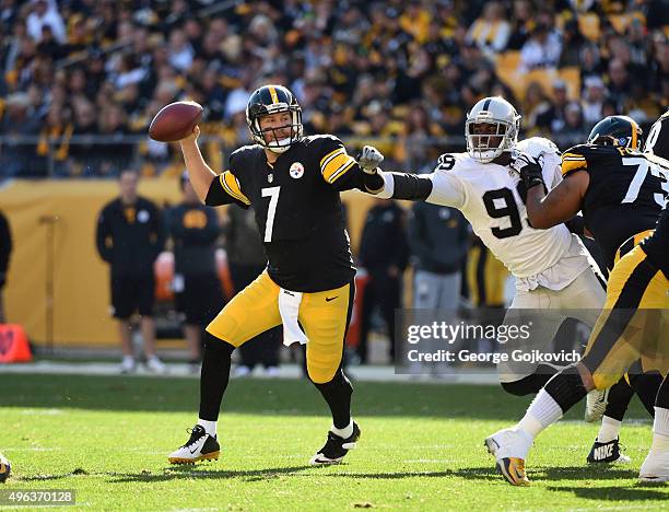 Quarterback Ben Roethlisberger of the Pittsburgh Steelers passes as offensive lineman Ramon Foster blocks linebacker Aldon Smith of the Oakland...