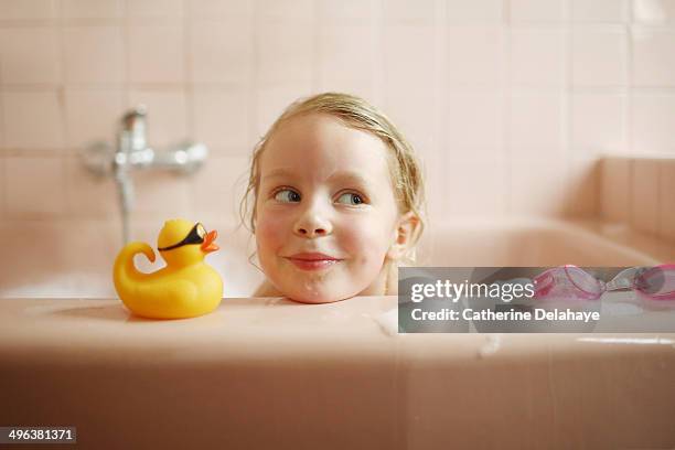 a 5 years old girl taking her bath - pato de juguete fotografías e imágenes de stock