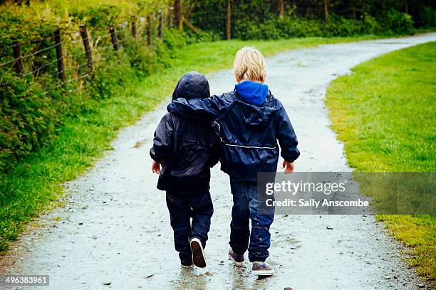 two little brothers walking together - siblings hugging stock pictures, royalty-free photos & images