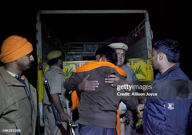 Policeman hugs Nawal Kishore Sharma after his 'cow vigilante' group chased down a truck that was smuggling cows on November 8, 2015 in Ramgarh,...