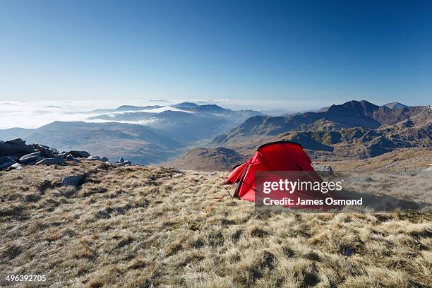 red tent on mountain side. - tent stock pictures, royalty-free photos & images