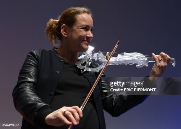 French Junior minister for Digital Economy Axelle Lemaire plays on the first 3D printed violin created with the Dassault Systemes software Catia, on...