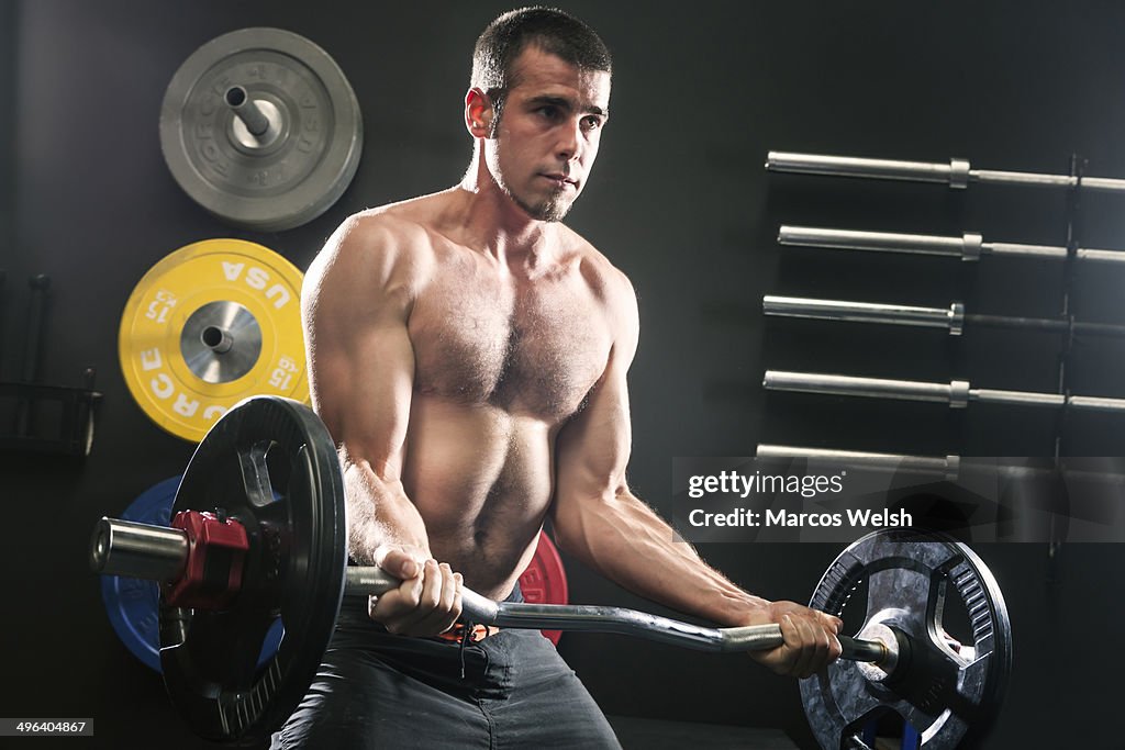 Fit man lifting weights in gym