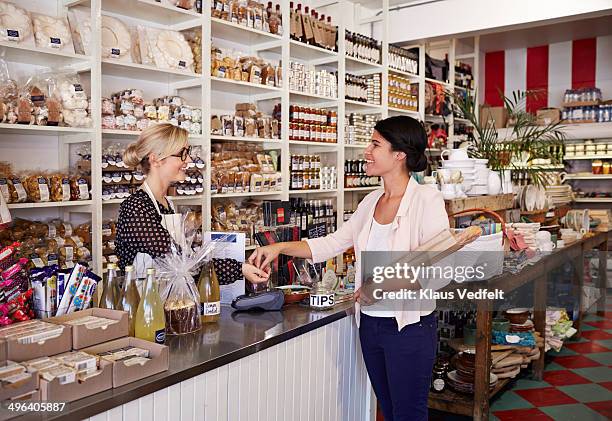 woman paying for a bread en deli shop - bakery shop stock pictures, royalty-free photos & images