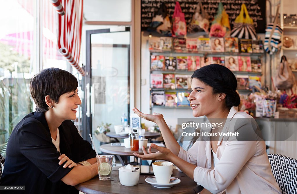 Girlfriends talking over a coffee at café