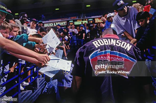 David Robinson of the San Antonio Spurs signs autographs against the Sacramento Kings circa 1993 at Arco Arena in Sacramento, California. NOTE TO...