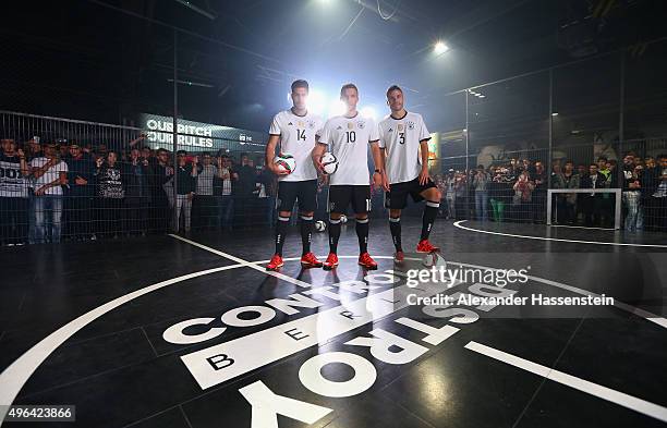 Emre Can, Lukas Podolski and Jonas Hector attend the adidas presentation of new DFB home jersey for UEFA EURO 2016 at The Base on November 9, 2015 in...