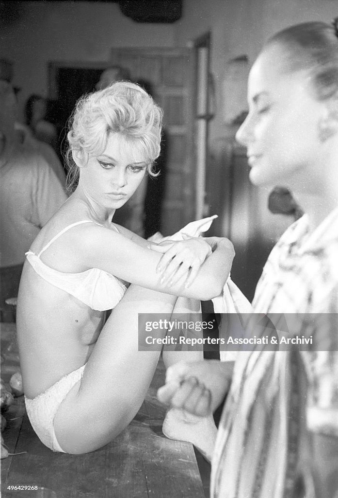 Brigitte Bardot sitting on a table on a film set