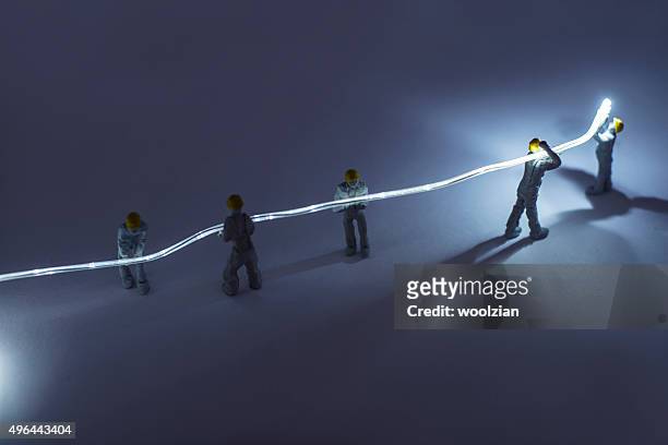 builders installing fibre optic - figurine stock pictures, royalty-free photos & images