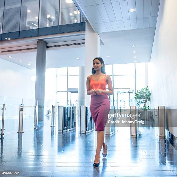 attractive young businesswoman in modern office foyer - ankle length stock pictures, royalty-free photos & images