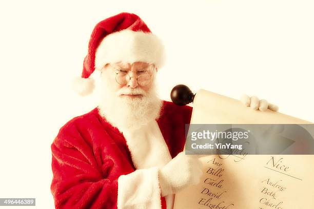 unhappy santa claus with naughter and nice name scroll - naughty santa stock pictures, royalty-free photos & images