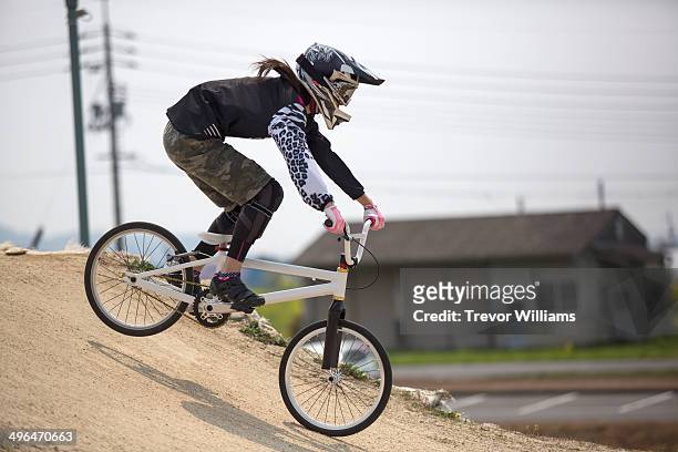 a young woman racing a bmx bike on a track - japan 12 years girl stock pictures, royalty-free photos & images