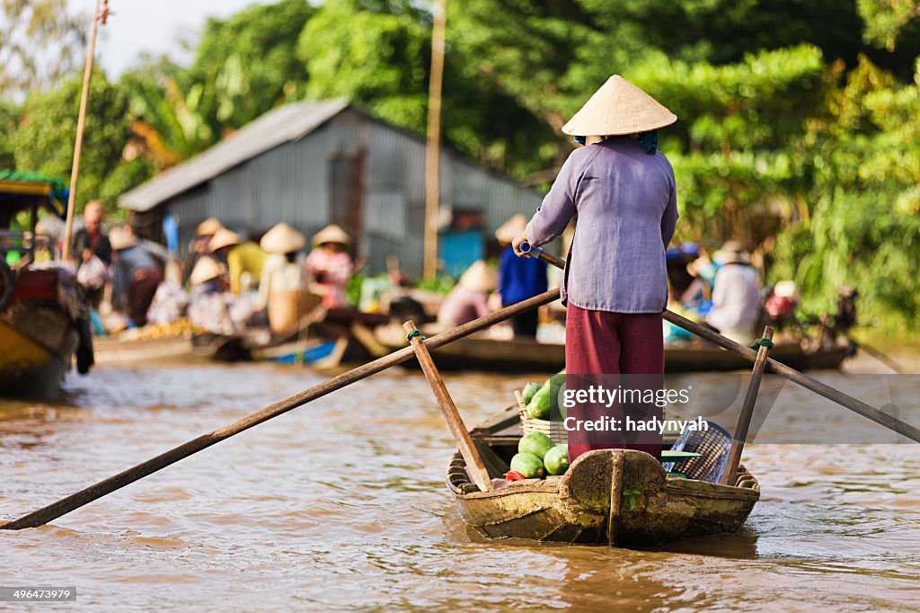 Vietnamese woman rowing boat in the Mekong River Delta, Vietnam